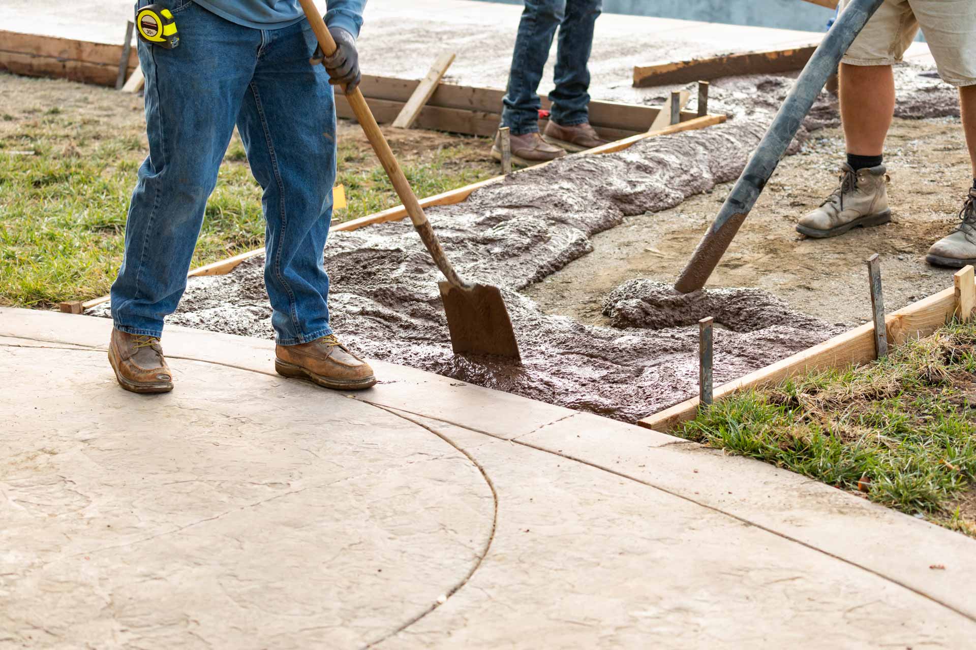 Men pouring concrete for decorative walkway